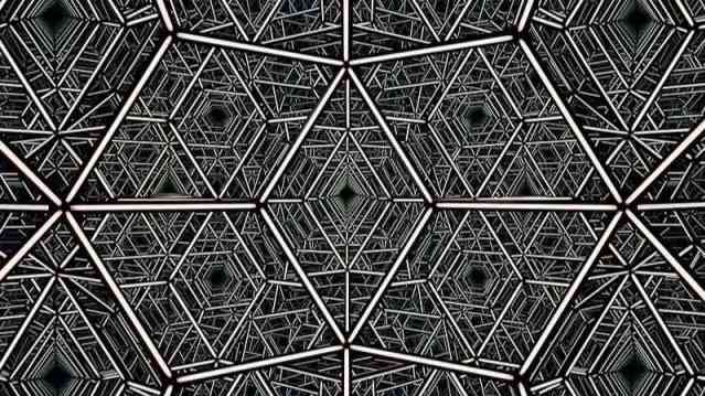 A geometric tunnel of repeating hexagonal metal frameworks forming a kaleidoscope-like pattern.