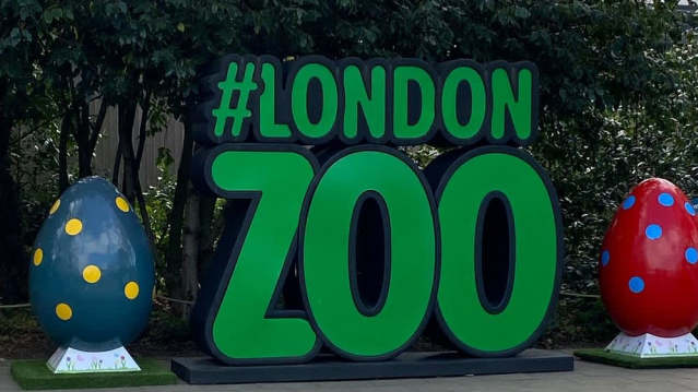 A large #London Zoo sign is displayed between two colorful, spotted egg sculptures.