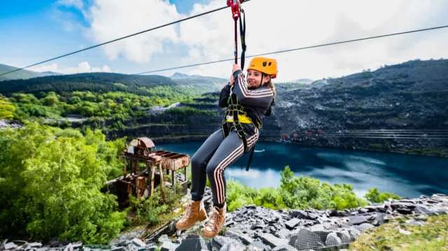 Child enjoying a thrilling zipline ride over Penrhyn Quarry at Zip World.