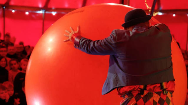 man pushing red ball